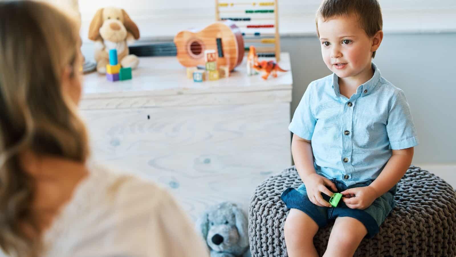 young boy talking to teacher.
