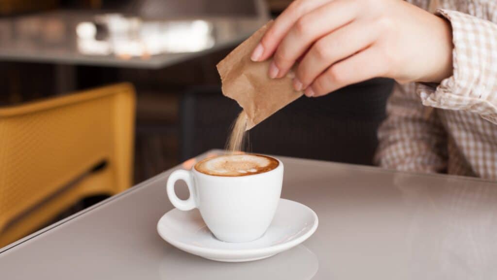 Adding sugar to coffee.