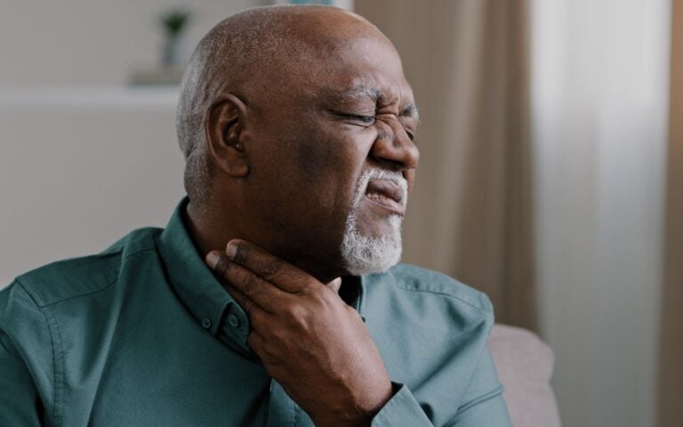 Sick African old man suffer from sore throat painful tonsillitis irritation senior male indoor check gland laryngitis bacterial infections diseases pain in neck severe ache cervical osteochondrosis