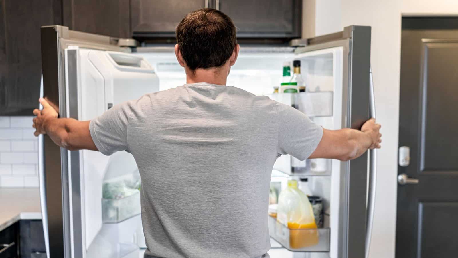 man looking at refrigerator. fridge.