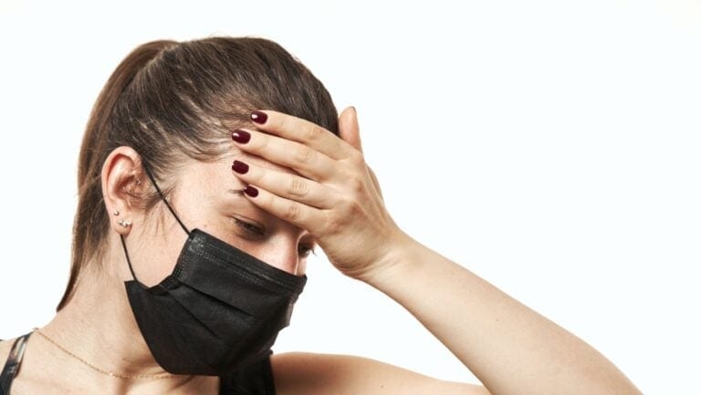 sick woman in mask. OlegRi via Shutterstock.