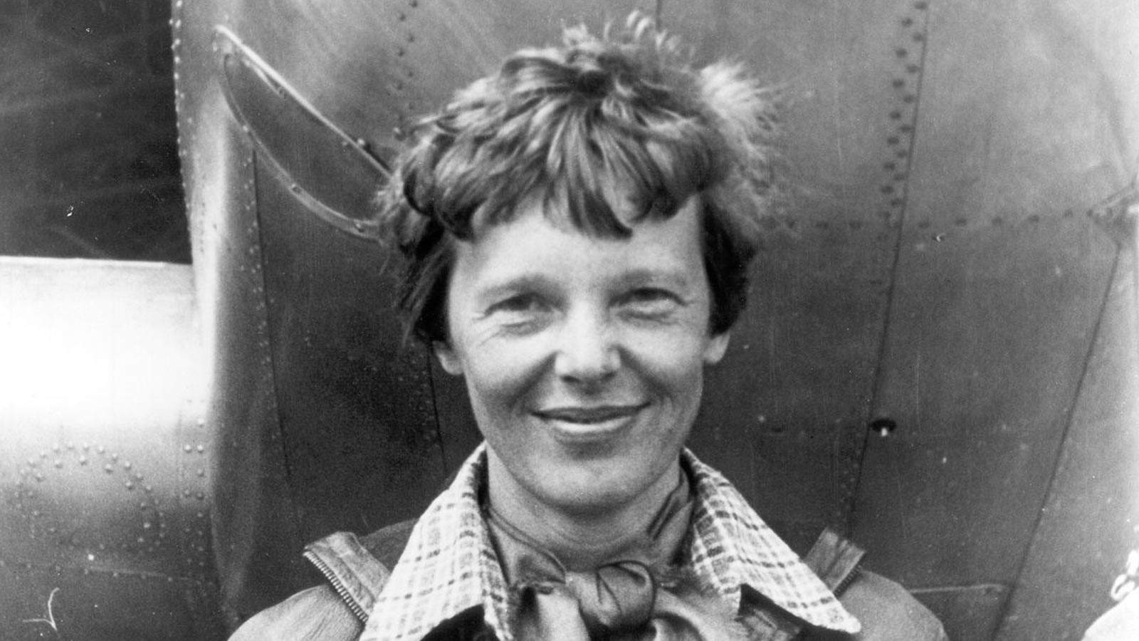 Amelia_Earhart_standing_under_nose_of_her_Lockheed_Model_10-E_Electra,_small.