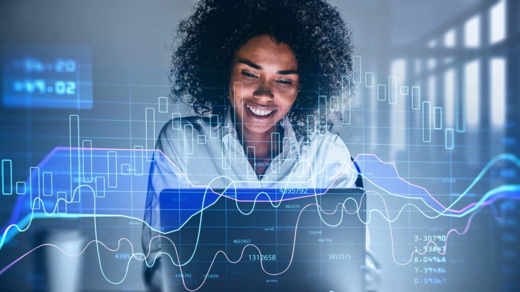 Attractive smiling African American business woman or stock trader analyzing stock graph chart using laptop, Portrait front view businesswoman.
