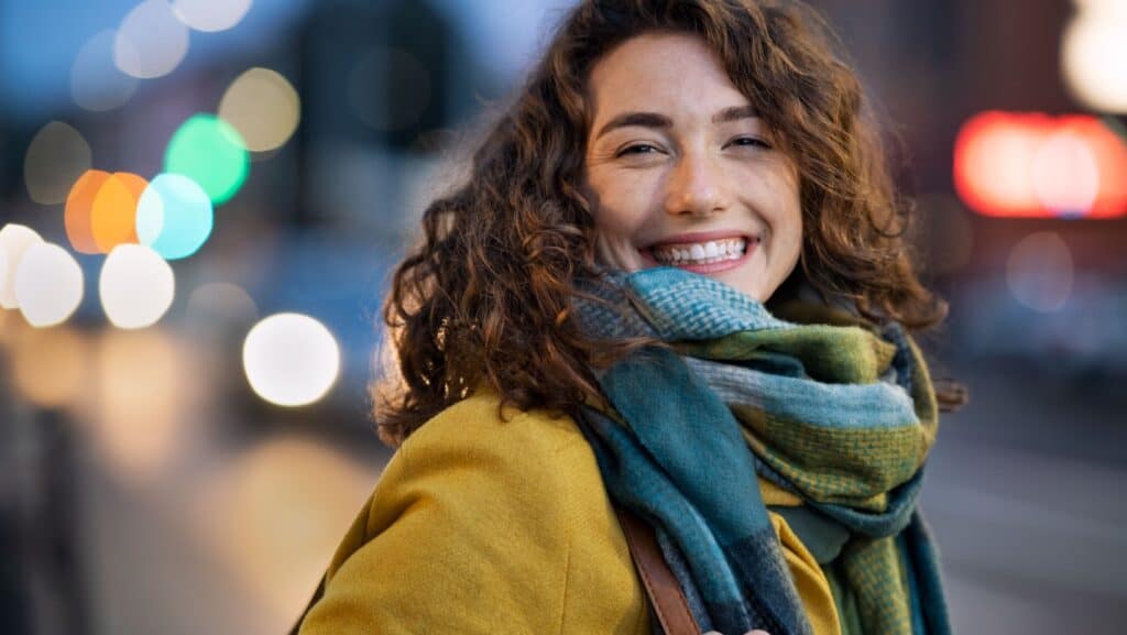 woman in scarf and coat. Happy.