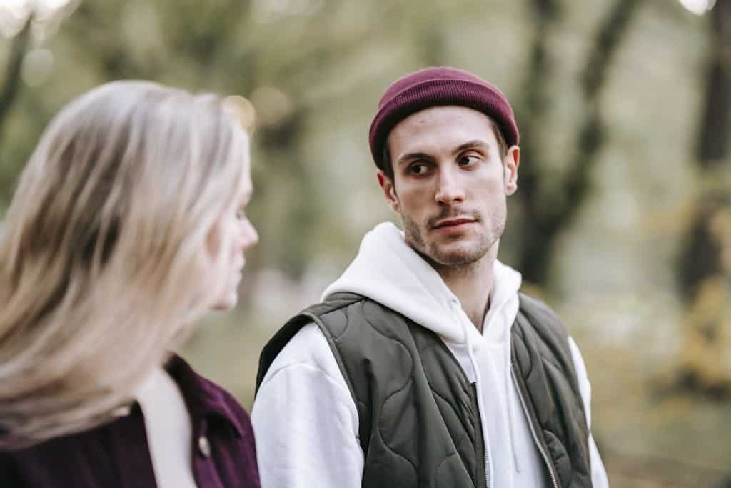 A young couple enjoying a peaceful walk in an urban park during daylight.