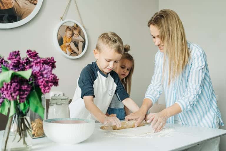 Mother and children enjoying a fun and messy baking session together at home.