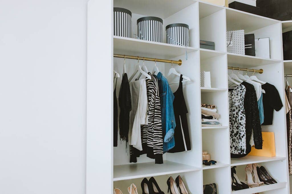 Neatly arranged wardrobe showcasing stylish clothes and shoes indoors.