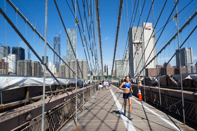 New York City, USA - August 4,2013 tourists and New Yorkers across the Brooklyn Bridge every day for sports, sightseeing or simply to get to work.