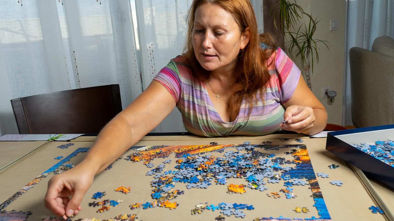 woman doing puzzle. barriolo82 via 123rf.