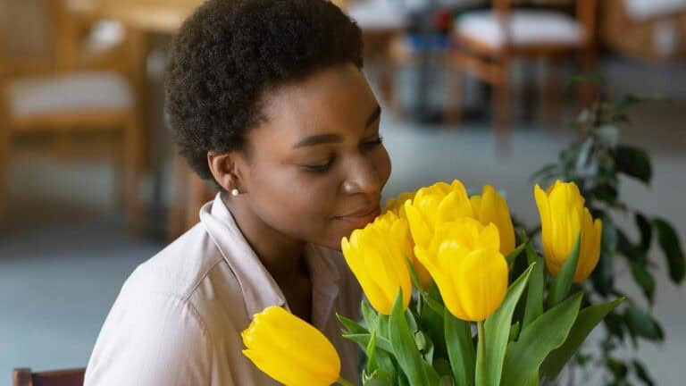 woman smelling tulips. milkos via 123rf.