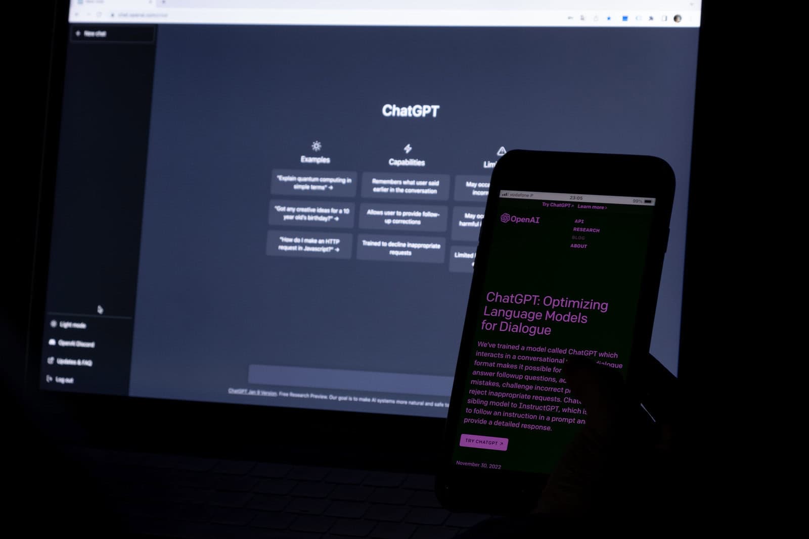 azvm Azores, Portugal - 12.01.2023: SmartPhone Screen with AI Chat GPT home page. Developed by OpenAI. In the background a laptop screen with chatbot prompt.