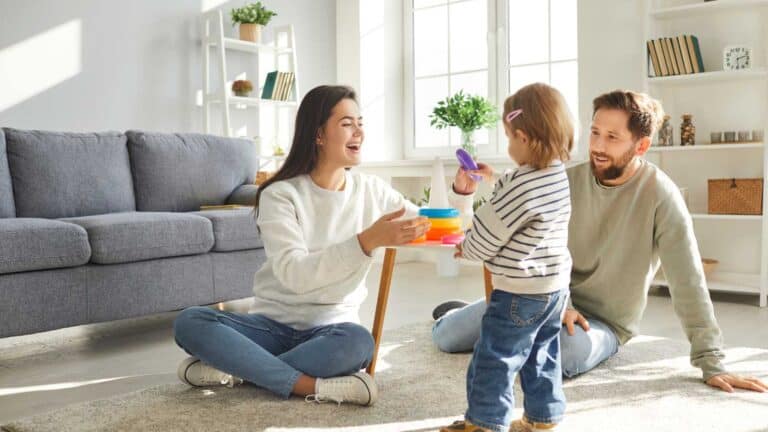 couple sitting on the floor with their cute little daughter