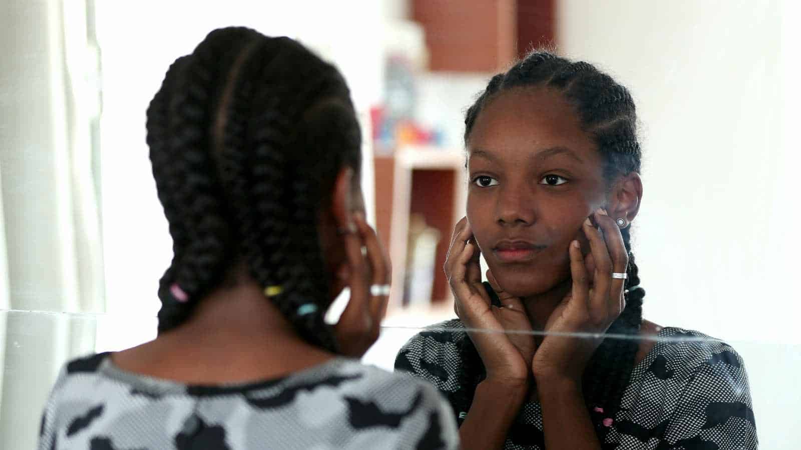 Black girl looking at her skin