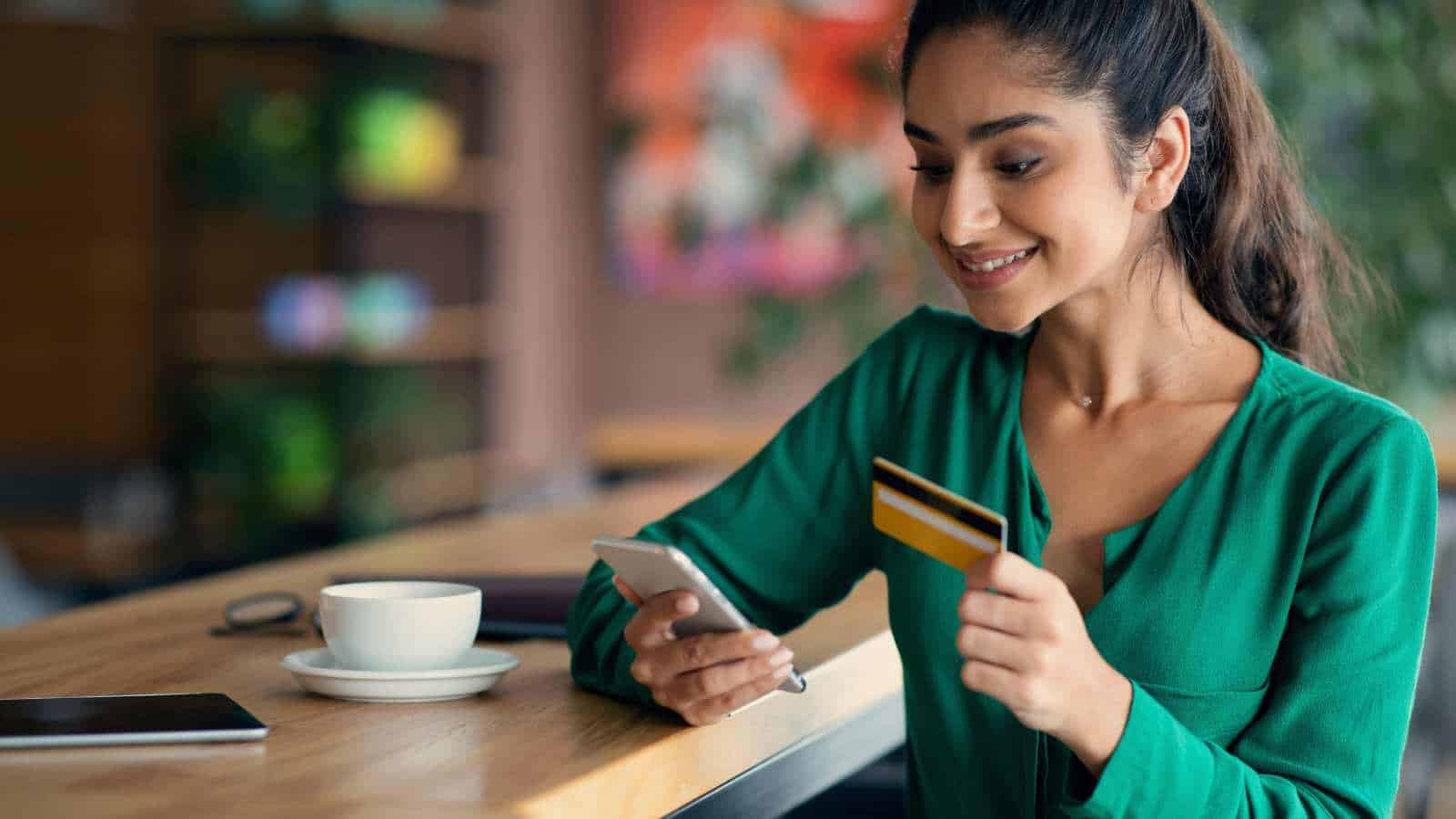 Woman paying with credit card at cafe shop