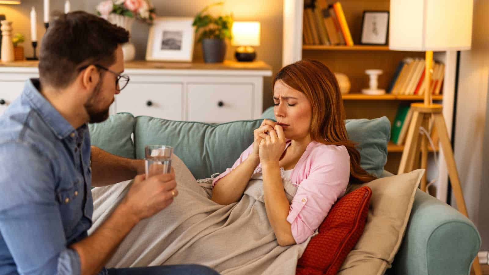 Caring man gently covers his sick wife with a warm blanket