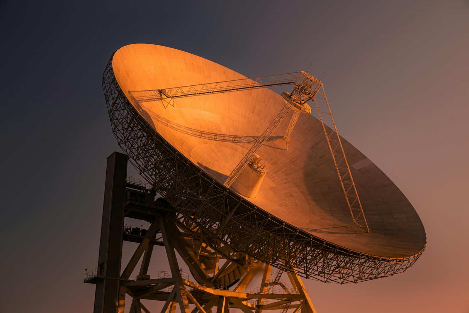 A striking satellite dish basking in golden hour light, capturing signals from space.