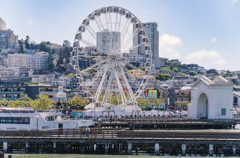 A vibrant image of a Ferris wheel at Pier 39 in San Francisco on a clear day.