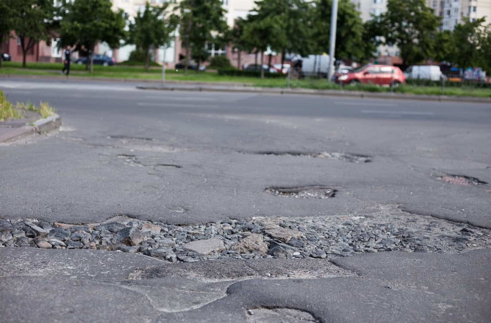 Broken asphalt and cracks on the road surface