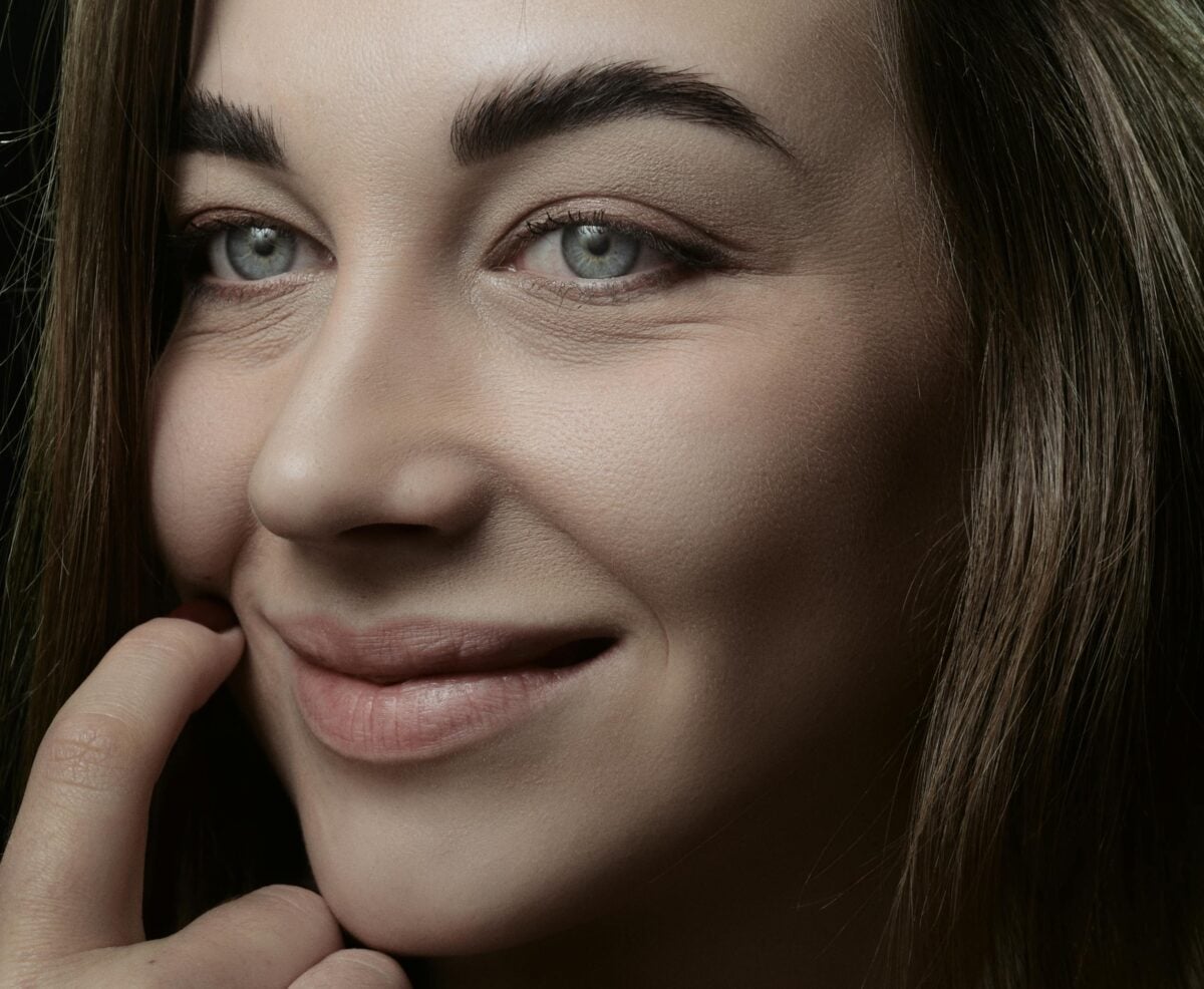 A close-up shot of a woman with a gentle smile and thoughtful expression.