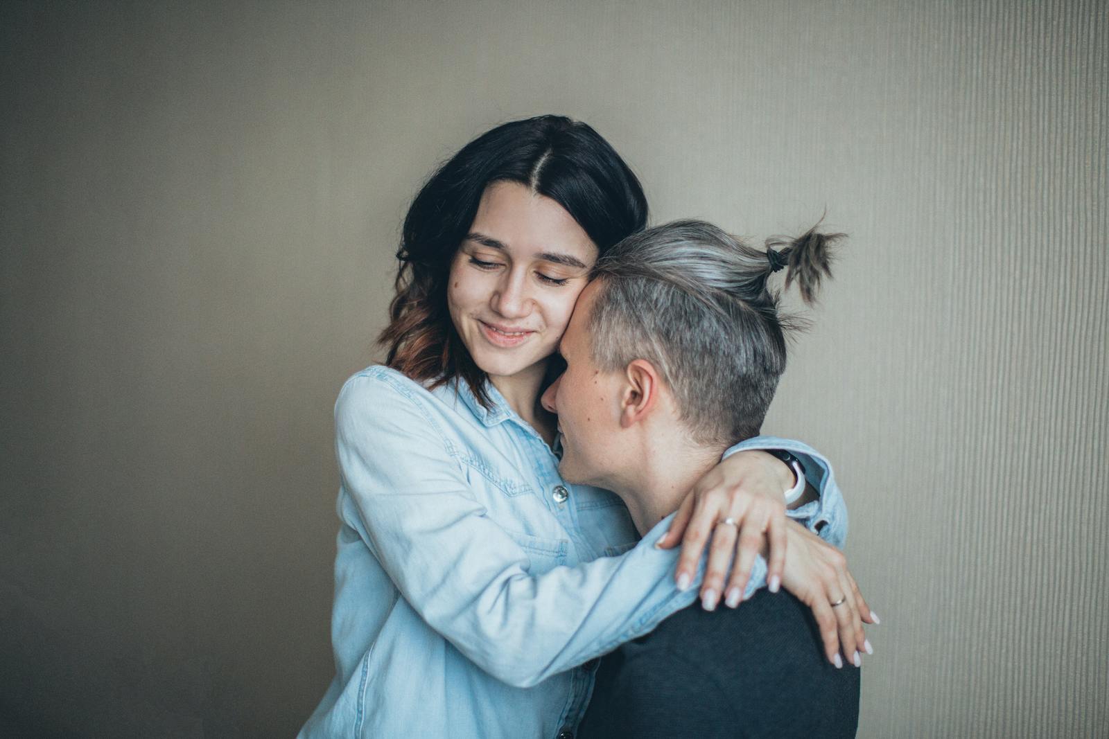 A couple sharing a warm hug indoors, showcasing love and emotional connection.