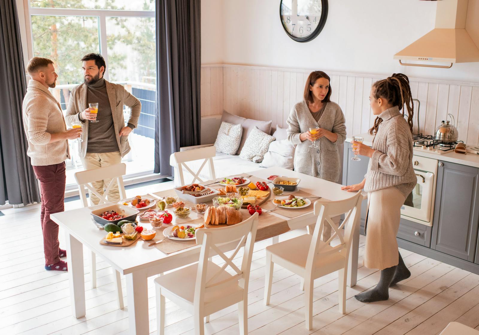 A cozy indoor breakfast with friends enjoying a variety of foods and orange juice.