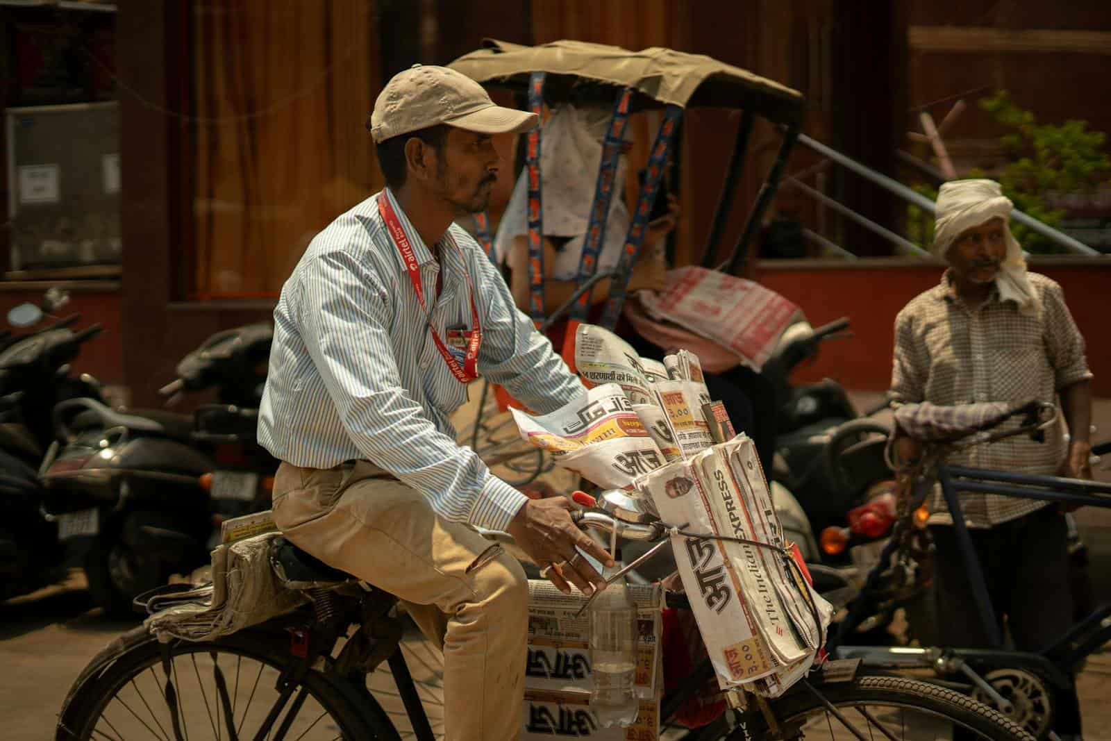 A newspaper vendor riding through Varanasi city streets, embodying daily life and hustle.