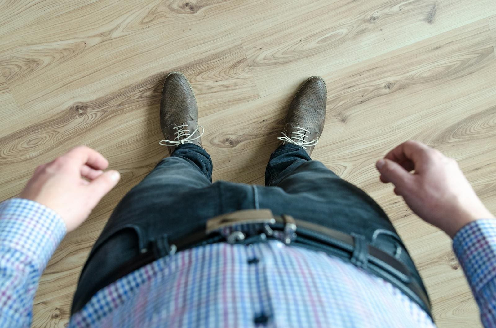 A top-down view of a man's outfit, showcasing a casual business look with shoes and checkered shirt.