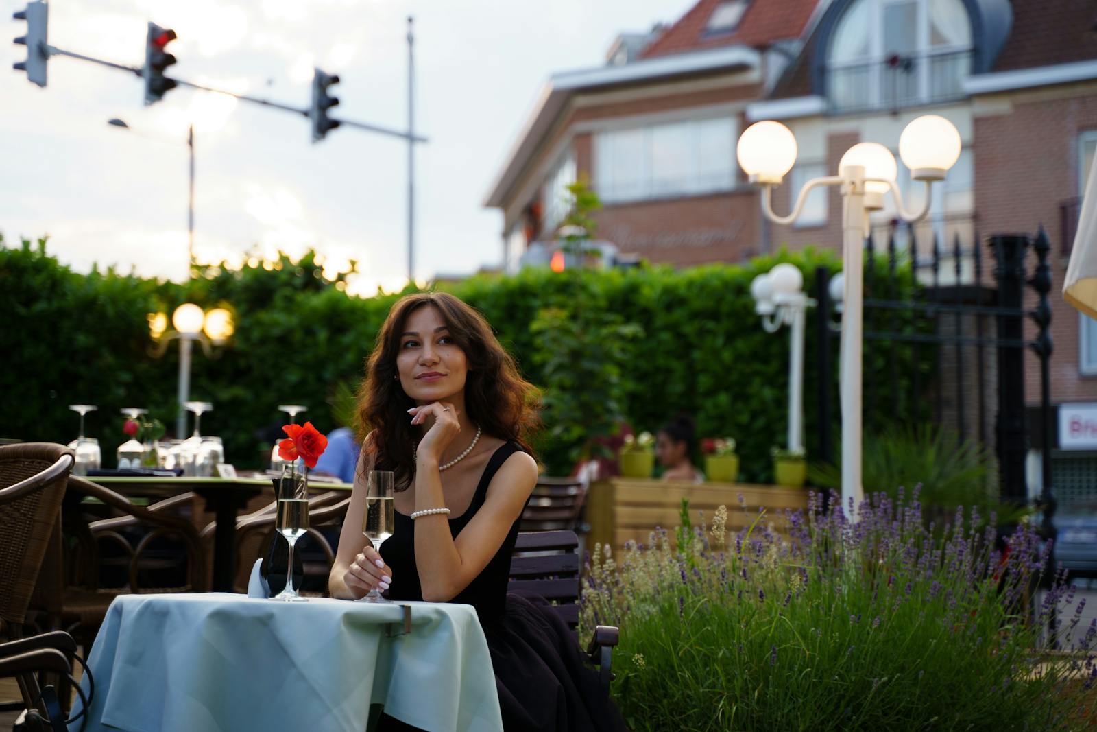 A young woman enjoying a romantic evening on a restaurant patio with champagne.