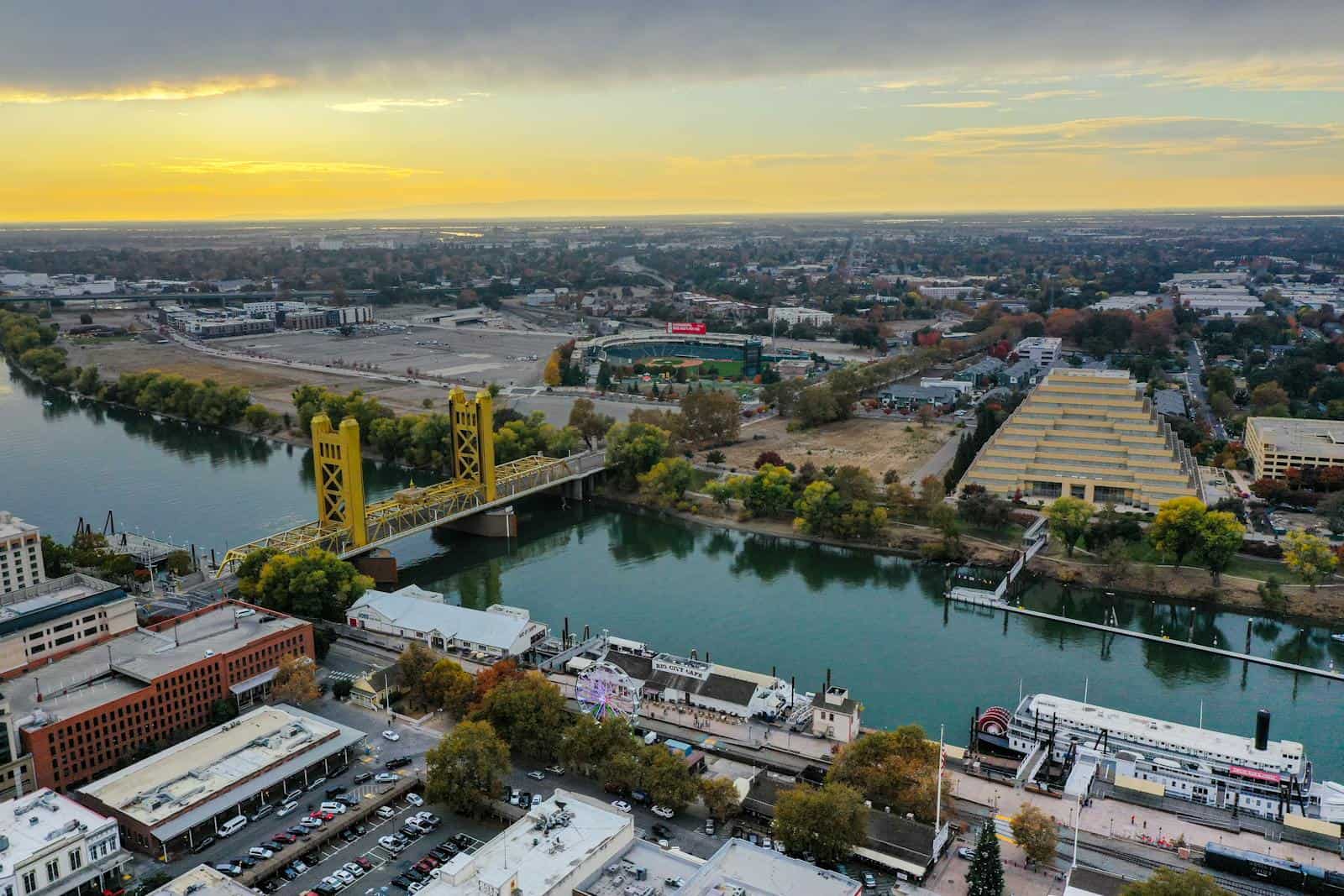 Aerial shot of the iconic Tower Bridge and Sacramento River at sunset, showcasing the city's skyline and landscape. California