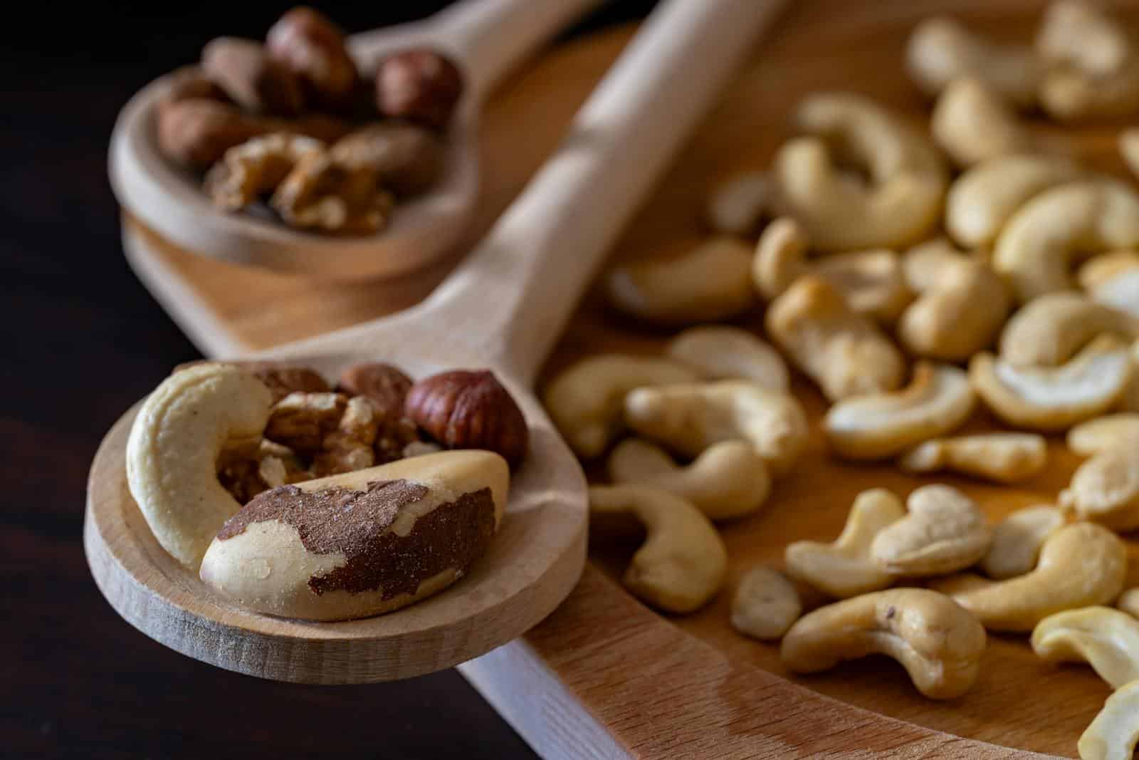 Close-up of mixed nuts including almonds, cashews, and walnuts on wooden spoons, ideal for healthy snacking. Brazil Nuts