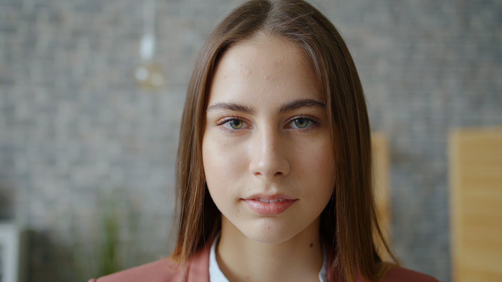 Close-up portrait of a young woman with a serene expression indoors.