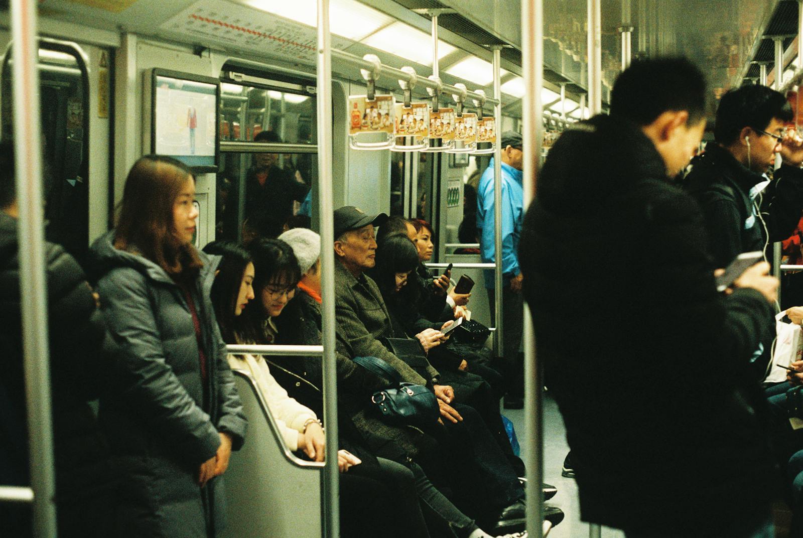 Crowded subway train in Shanghai with commuters sitting and standing, public transportation scene.