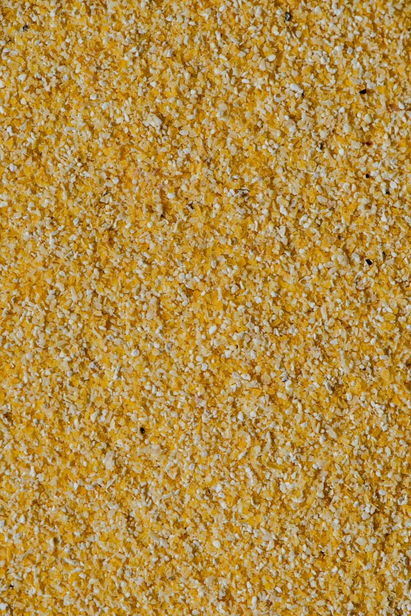 Detailed close-up of yellow corn grits showcasing texture and color in Estonia.