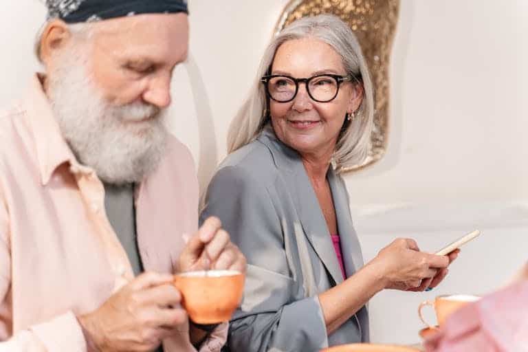 Elderly couple enjoying coffee and conversation in a cozy indoor setting. Senior