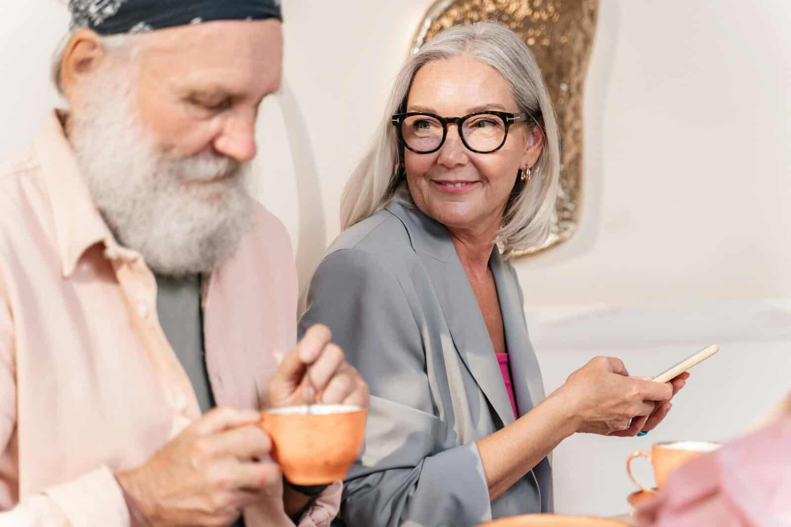 Elderly couple enjoying coffee and conversation in a cozy indoor setting. Senior