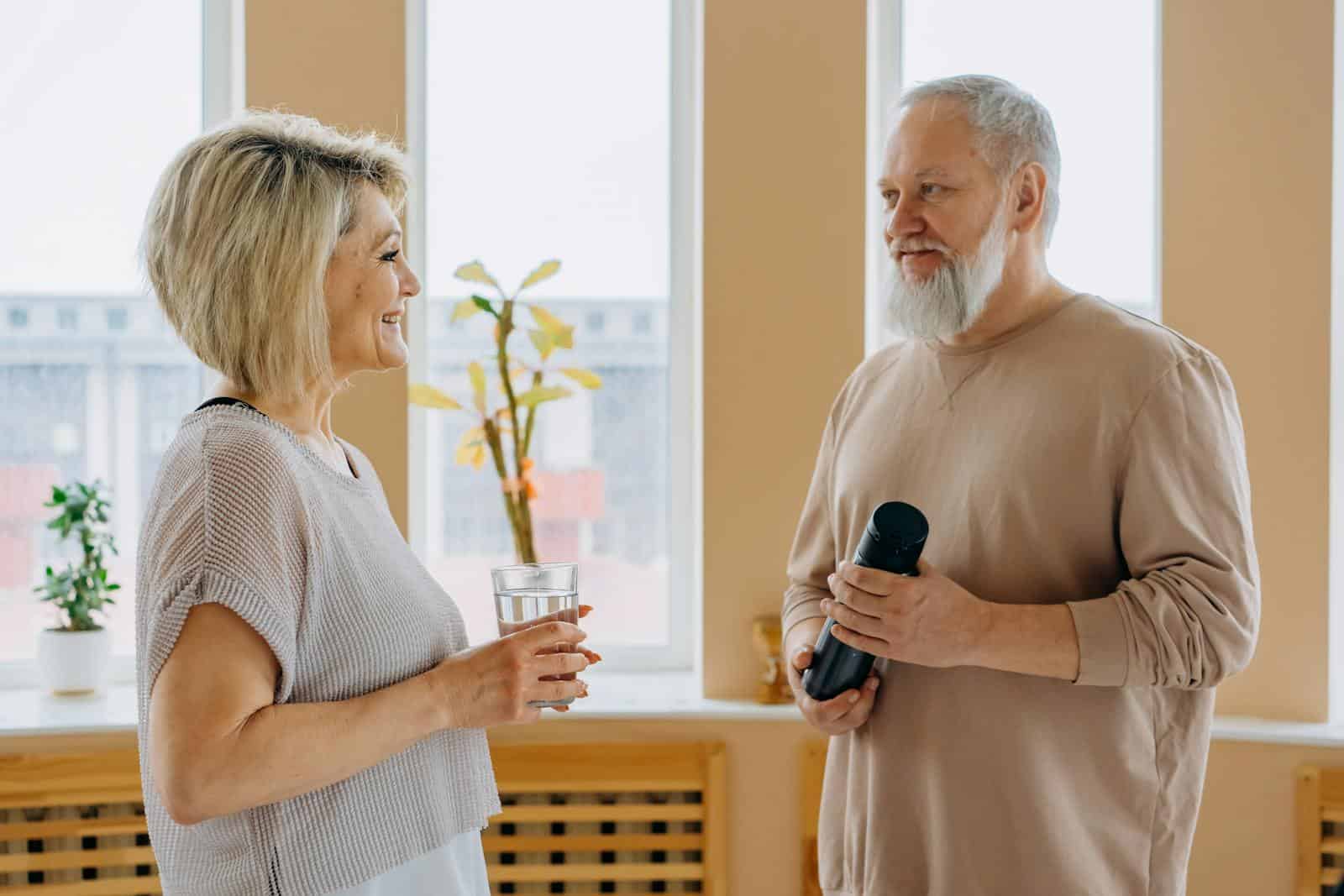 Elderly couple smiling and talking indoors, promoting a healthy lifestyle. senior