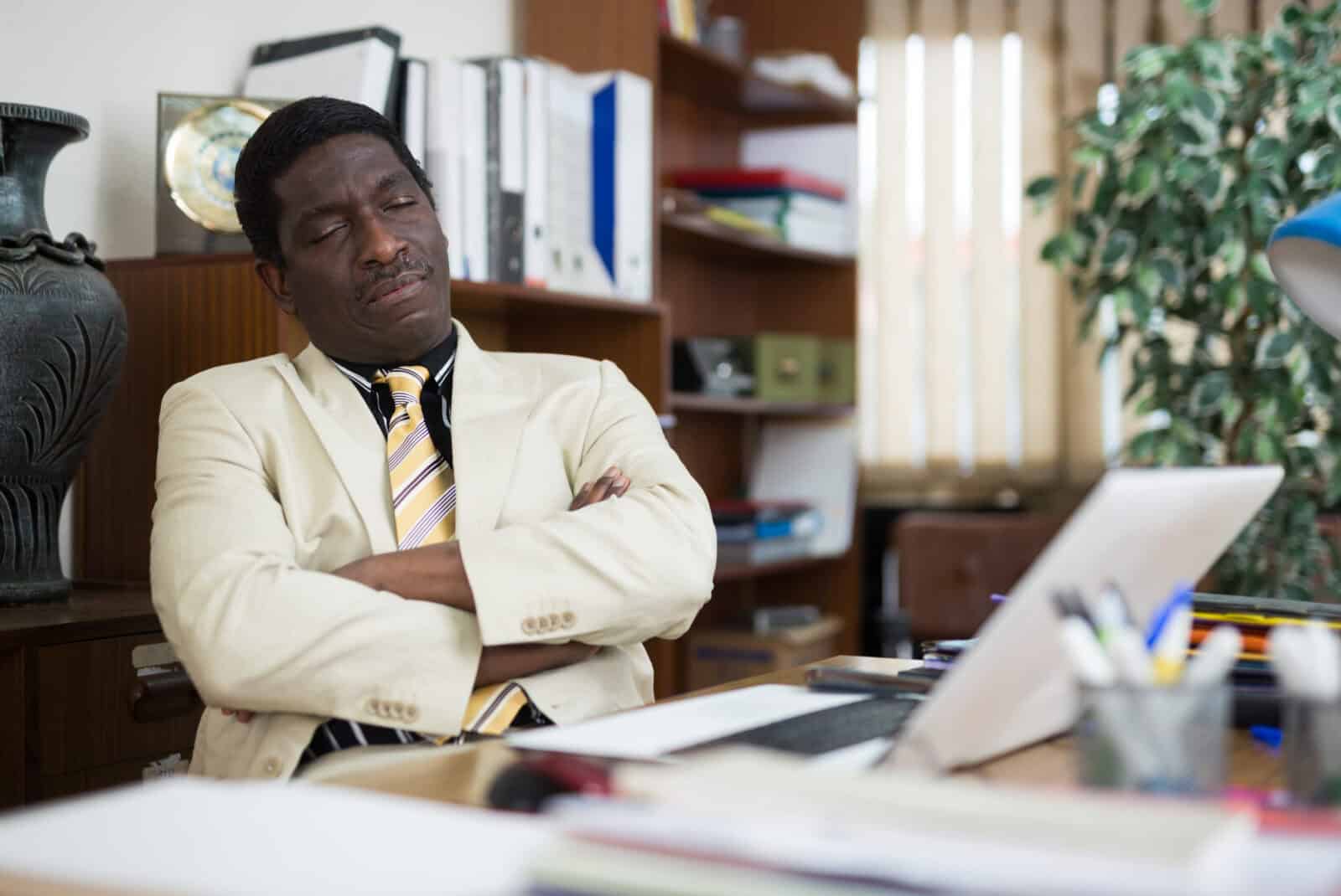 Tired businessman fell asleep at the desk in office