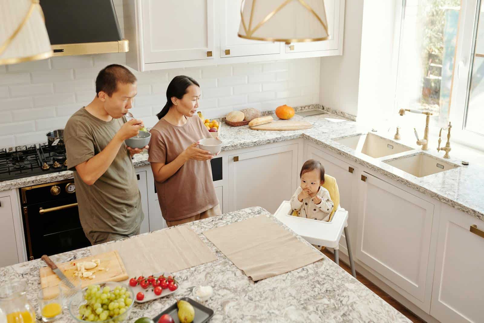 Asian family having breakfast together in a cozy kitchen. Parents and toddler in a high chair. Strict Kitchen Boundaries