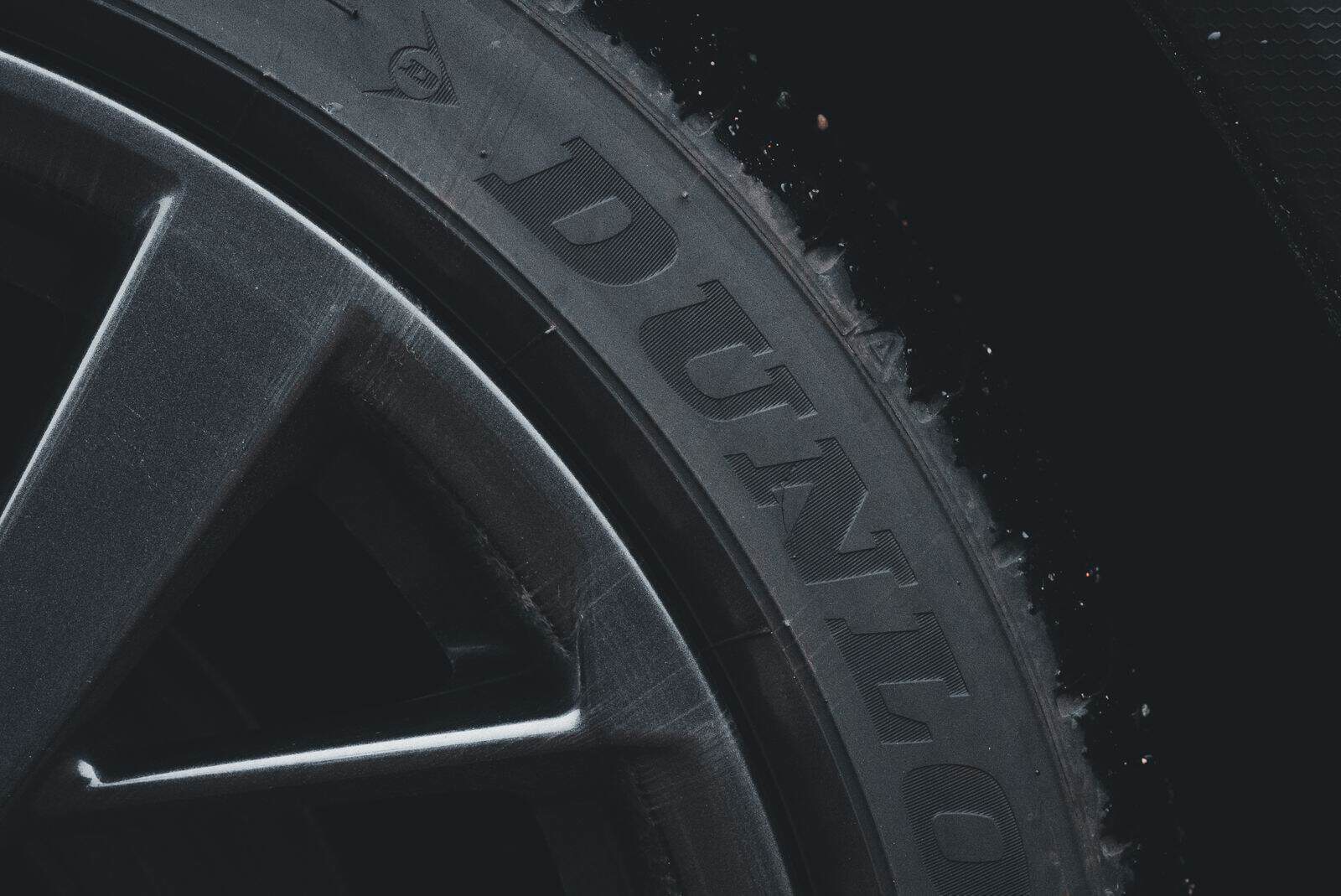 Detailed close-up of a Dunlop tire and rim showcasing its texture and brand text.