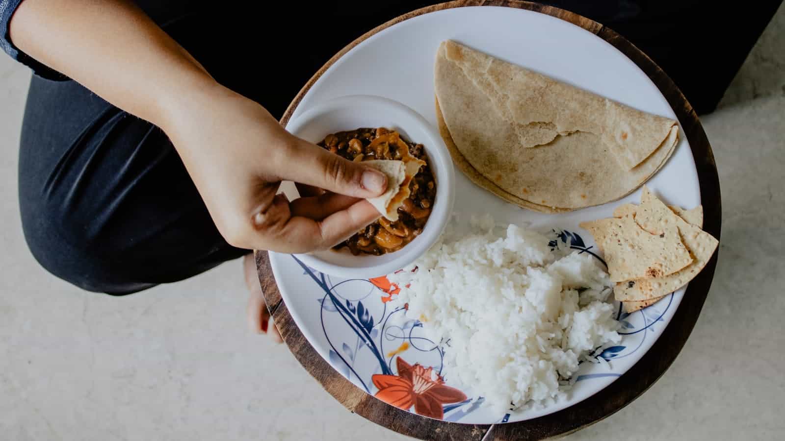 Top view of a traditional Indian meal with chapati, rice, and beans.