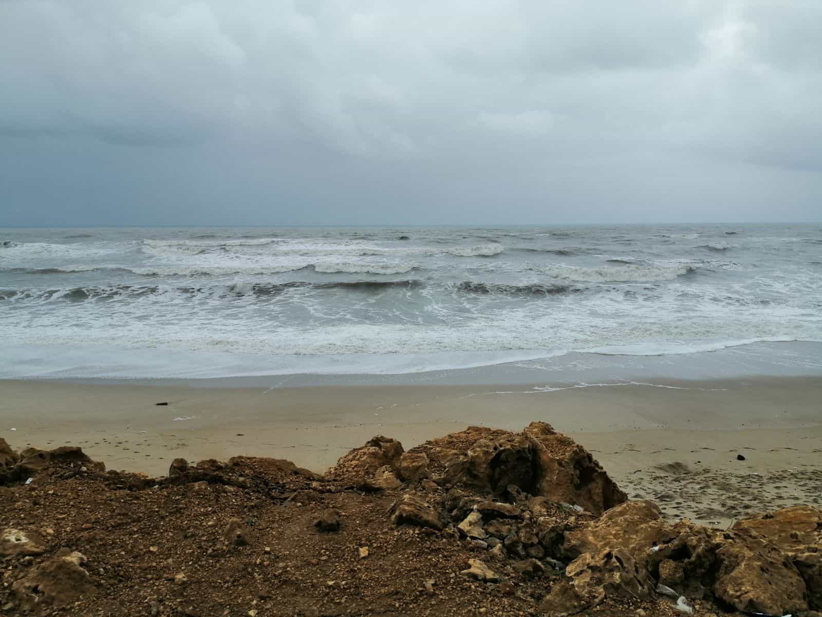 A dynamic view of the ocean with waves crashing against a rocky shore under a cloudy sky, ideal for dramatic landscapes.