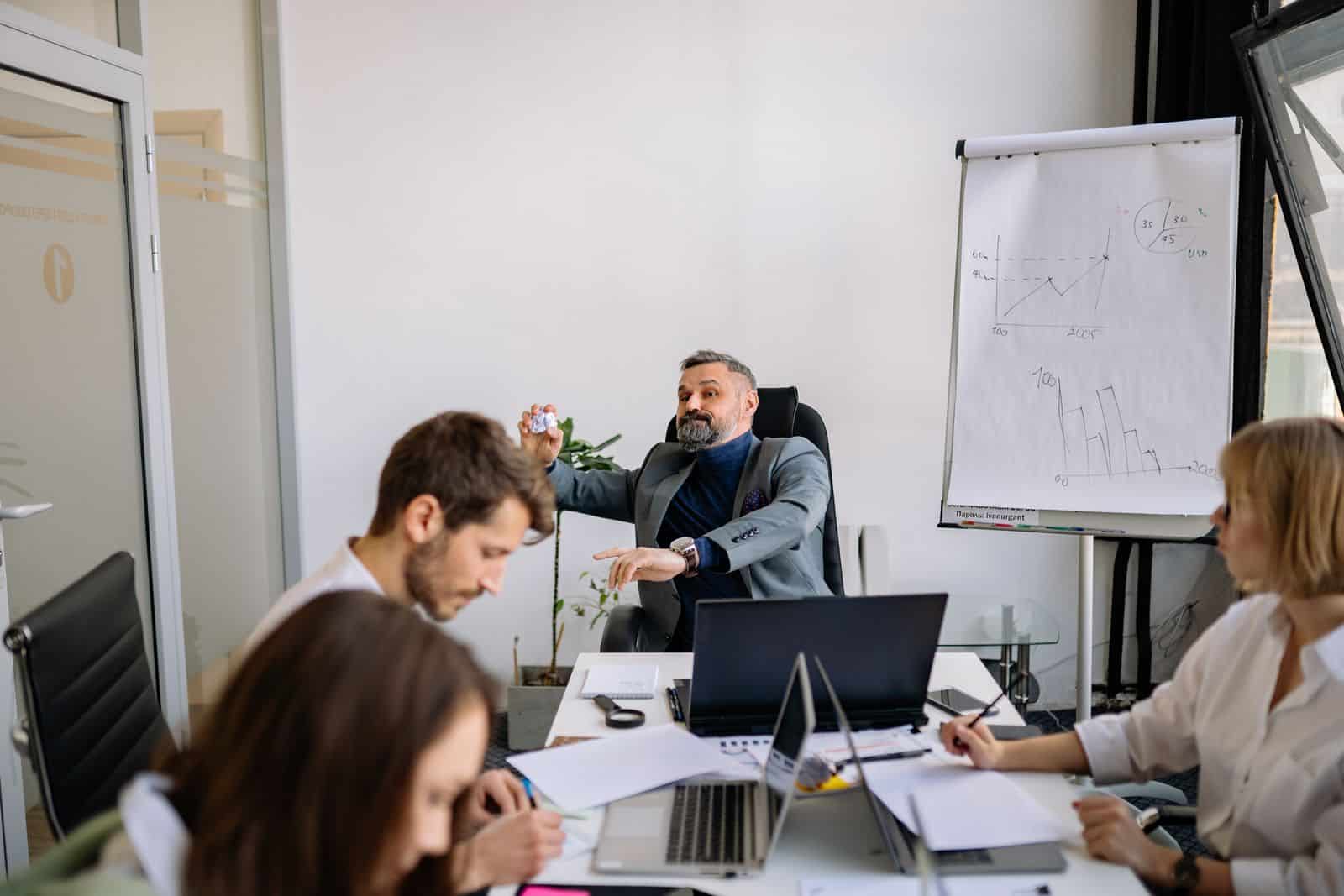 Business professionals engaged in a lively discussion during a meeting in an office setting.